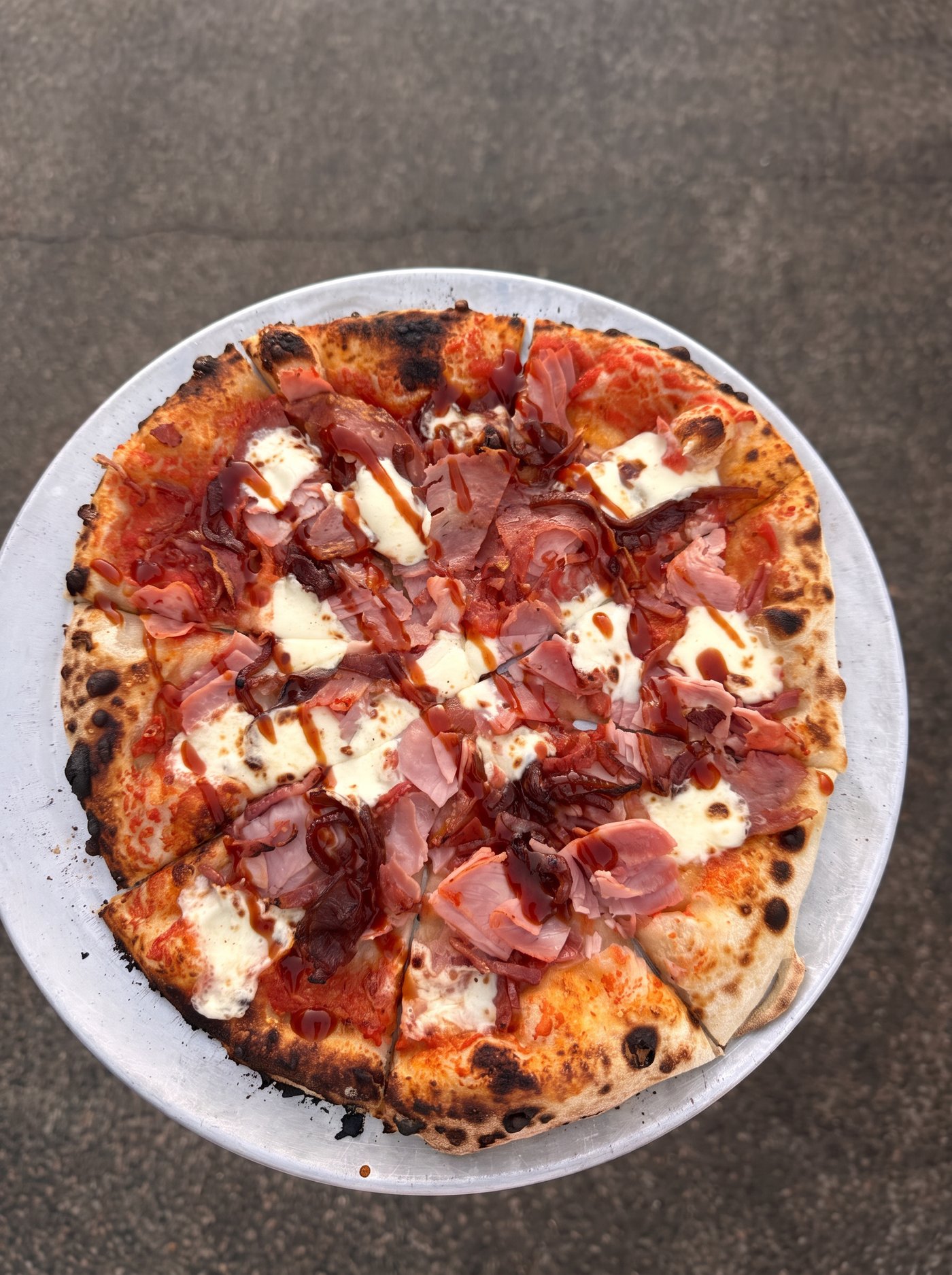 Freshly baked Tribe sourdough pizza topped with melted cheese and cured ham